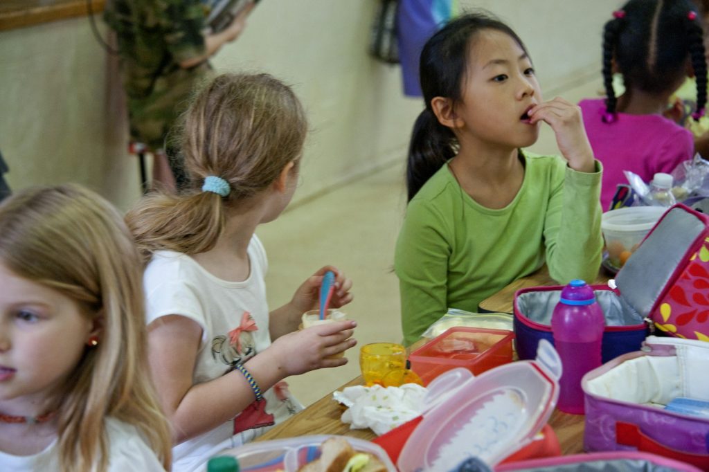 Elementary school students eating lunch together in the cafeteria