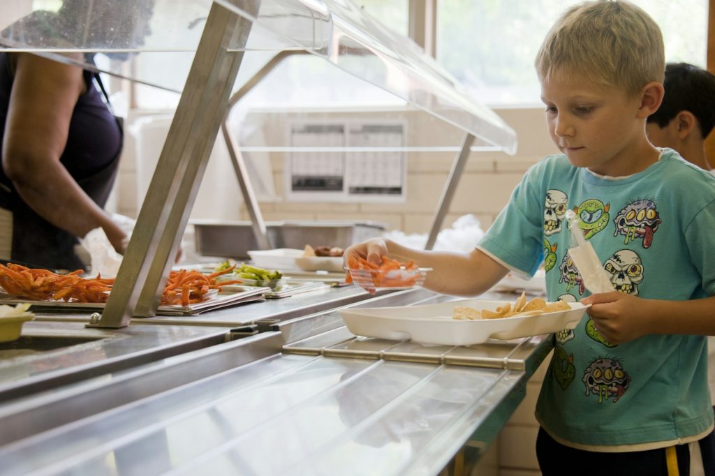 Student choosing a hot lunch at the school serving line